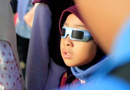 Terpesona. Seorang anak tampak terpesona dengan fenomena alam Gerhana Matahari Total yang disaksikan